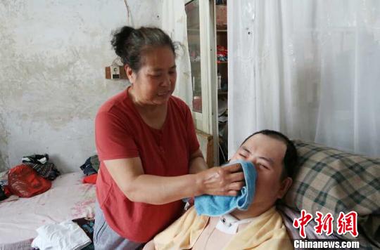 每次喂完食物后，梁青蘭都要仔細(xì)地幫兒子清理干凈。　尚明俠 攝