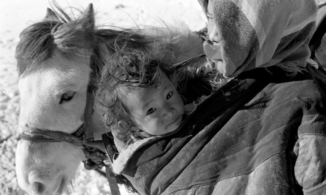 1990年3月，西藏當(dāng)雄縣納木湖鄉(xiāng)三村女牧民斯卓不畏嚴(yán)寒，懷抱幼子，準(zhǔn)備到遠(yuǎn)處放牧。新華社記者覺果攝