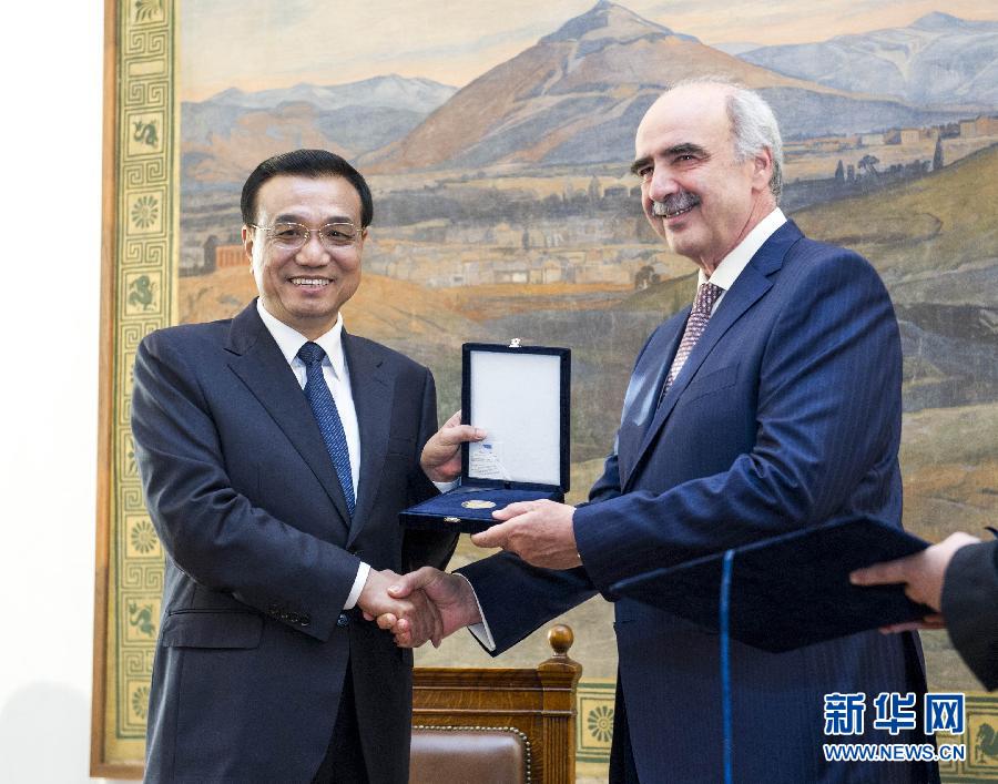 6月19日，國務院總理李克強在希臘議會大廈會見希臘議長米馬拉基斯。這是會見前，米馬拉基斯代表希臘議會向李克強授予議會金質勛章。新華社記者 王曄 攝