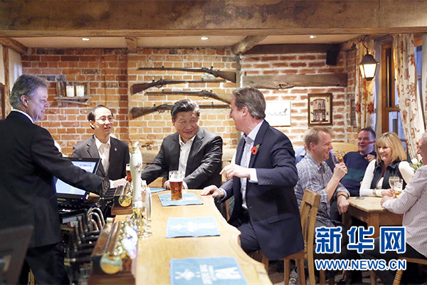 這是會晤結束后，習近平在卡梅倫陪同下乘車前往當地小鎮(zhèn)體驗酒吧文化。新華社記者 鞠鵬 攝